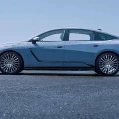 Nowy Lexus ES w błękitnym kolorze, prezentujący swoją elegancką sylwetkę na tle błękitnego nieba i morza.