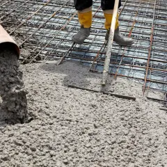 Wylewanie betonu na zbrojenie fundamentów.