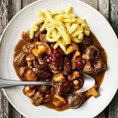 Herzhaftes Rehgulasch mit Rotwein, Pilzen und Preiselbeeren, serviert mit Spätzle. Ein köstliches Rehgulasch Rezept.