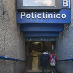 Due persone scendono le scale verso l'ingresso della stazione policlinico metro B.
