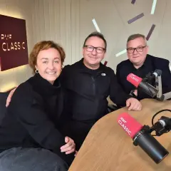 Trzy osoby w studiu RMF Classic. Na stole mikrofony z logo RMF Classic, które można usłyszeć na tej częstotliwości.