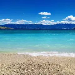 Idealne miejsce, gdzie w czerwcu na wakacje. Turkusowe morze, kamienista plaża i góry w tle.
