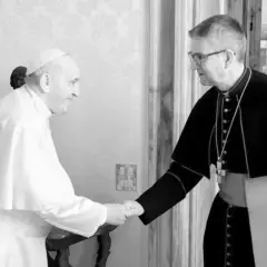 Papst Franziskus, seit wann ist Franziskus Papst, schüttelt einem Bischof die Hand.