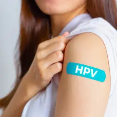 Ramię z plastrem z napisem HPV. Po szczepieniu mam HPV, co z seksem? Bezpieczeństwo przede wszystkim.