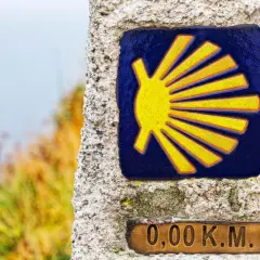 Das Jakobsweg Symbol Bedeutung: Eine gelbe Muschel auf blauem Grund, die den Beginn der Pilgerreise markiert. 0,00 km.