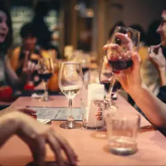 Amis partageant un bon type vin rouge et blanc autour d'une table rose.
