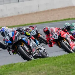 Pilotos de superbikes compiten en una carrera, inclinándose en una curva. ¡Emoción pura donde ver superbikes!