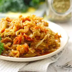 Piatto di verza stufata con carote, guarnito con prezzemolo. Un classico sapore di verza stufata ricetta della nonna.