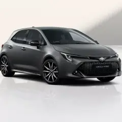 Szary hatchback Toyota Corolla 1.8 Hybrid z czarnymi felgami stoi na białym tle.