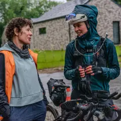 Dwie rowerzystki rozmawiają w deszczu podczas wyścigu Małopolska 500.