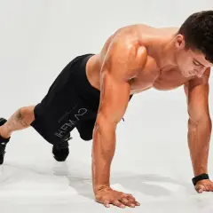 Hombre haciendo flexiones en posición de plancha, listo para un entrenamiento de **hiit en casa**.