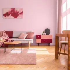 Salon w odcieniach brudny róż kolor. Sofa, dywan i zasłony tworzą przytulną atmosferę.