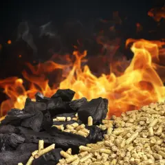 Węgiel drzewny i pellet obok siebie, płomienie w tle. Czy można mieszać pellet z ekogroszkiem?