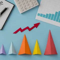 Notatnik z napisem "SUCCESS", kalkulator, wykres słupkowy i czerwona strzałka w górę symbolizują udany marketing performance.