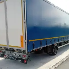 Ciężarówka z niebieską plandeką i białymi drzwiami z tyłu. Zastanawiasz się, ile waży ciągnik siodłowy?