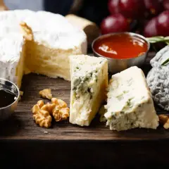 Assaggio di formaggi: un cremoso, un erborinato con venature blu e un formaggio grigio. Accompagnati da noci, miele e uva rossa.