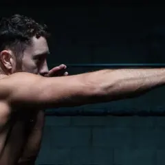 A boxer throws a powerful right jab, his muscles tensed and ready.