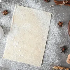 Ciasto francuskie na blacie, obok jajko i przyprawy. Zastanawiasz się, czy ciasto francuskie można mrozić? Tak, można!