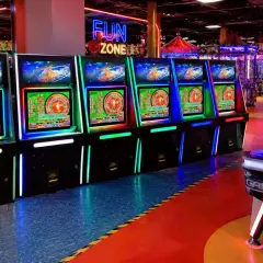 Rząd podświetlanych maszyn do gry zręcznościowej w "Fun Zone", gdzie każdy może spróbować szczęścia.