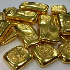Złote sztabki i monety, symbolizujące stabilność i inwestycję, gdy cena złota na Ukrainie jest tematem dyskusji.