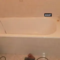 Salle de bain avant rénovation baignoire : baignoire blanche fissurée, robinetterie ancienne, carrelage beige.