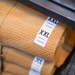 Na wadze leżą ubrania w rozmiarze XXL i XL.