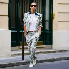 Un outfit da colloquio di lavoro senza tacchi: tailleur floreale con blazer e pantaloni ampi, t-shirt bianca e sneakers.