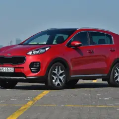 Czerwony Kia Sportage na parkingu, idealny do miasta i na dalsze trasy. Zastanawiasz się nad jego kia sportage spalanie?