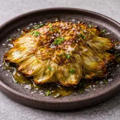 Deliciosas alcachofas a la plancha, doradas y tiernas, bañadas en aceite de oliva y espolvoreadas con sal marina y perejil fresco.