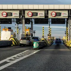 Bramki autostradowe e-TOLL z samochodami i znakami ograniczenia wysokości.