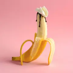 Banan z polewą czekoladową i bitą śmietaną, sugerujący polknięcie spermy.