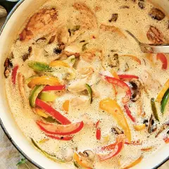 En krämig kycklinggryta med ris, fylld med färgglada paprikor och champinjoner. En härlig måltid som värmer.