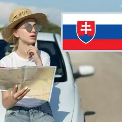 Kobieta z mapą przy aucie, zastanawia się nad trasą na Słowacji. Flaga Słowacji obok.
