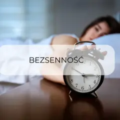 Kobieta w łóżku, budzik obok. Bezsenność co to? Czas ucieka, sen nie przychodzi.