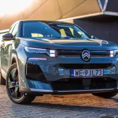 Nowoczesny, ciemnoszary francuski samochód z charakterystycznym logo Citroëna na masce, zaparkowany na brukowanej nawierzchni.