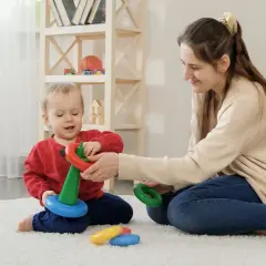 Mama i dziecko bawią się kółkami, rozwijając zdolności motoryczne. Radość i nauka w jednym.