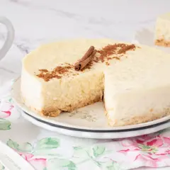 Deliciosa tarta de arroz cremosa, decorada con canela en rama y espolvoreada. Un trozo ya servido.