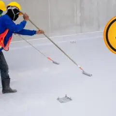 Operai con caschi e maschere applicano resina. Il simbolo del teschio indica che respirare resina fa male.