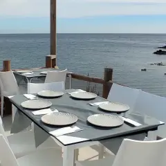 Mesas puestas en un restaurante de Almería con vistas al mar.
