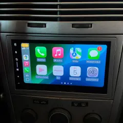 Nowe radio Android w Oplu Astra H z ekranem dotykowym i ikonami aplikacji: Telefon, Muzyka, Mapy, Wiadomości, Odtwarzane, AV, Kalendarz, Ustawienia.
