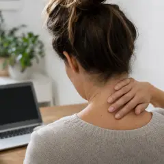 Donna con mano sul collo, che soffre di cervicobrachialgia. Quanto dura questo dolore?