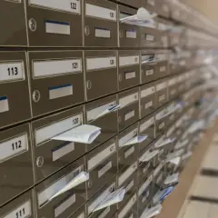 Rząd numerowanych skrytek pocztowych, niektóre z listami. Wyobraź sobie, że każdy z nich ma swój unikalny kod pocztowy Warszawa.