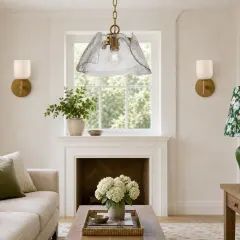 Elegante lámpara colgante cristal vintage ilumina un salón acogedor con sofá, chimenea y detalles florales.