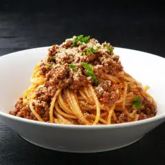Spaghetti bolognese, prosty przepis. Aromatyczny sos mięsny na złocistym makaronie, posypany parmezanem i natką pietruszki.