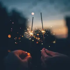 Mani che accendono scintille al tramonto, un modo magico per festeggiare, come si dice capodanno in inglese?