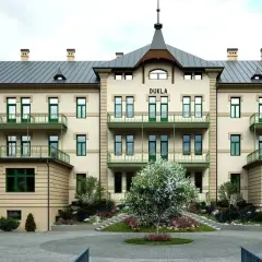 Elegancki budynek DUKLA z zielonymi balkonami i drzewkiem przed wejściem. Sprawdź bardejowskie termy cennik i zaplanuj relaks.
