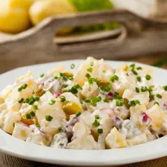 Pyszna, oryginalna kartoffelsalat z ziemniaków, ogórków kiszonych i cebuli, posypana szczypiorkiem.