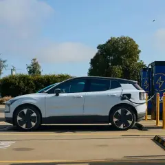 Voiture électrique blanche branchée à une borne de recharge. Un avantage véhicule électrique : l'énergie propre pour un avenir durable.