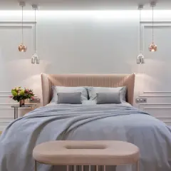Achieve that hotel bed at home feeling with this plush, inviting bedroom setup. Soft linens, a cozy throw, and elegant lighting create a serene sanctuary.