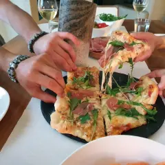 Pieczenie pizzy na kamieniu zakończone sukcesem! Rozciągający się ser i rukola kuszą.